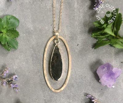 Teardrop shaped labradorite gemstone surrounded by gold electroplating and a free hanging hammered brass oval.  They sit on a 30" gold plated chain with 2" extender. 