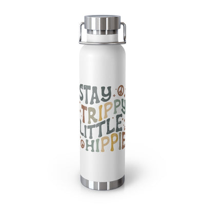 White vacuum insulated bottle with stainless steel cap and handle. The artwork says Stay Trippy Little Hippie. There are accents of peace signs and stars. All of the artwork is in grey, blue, green and yellow earth tones. 