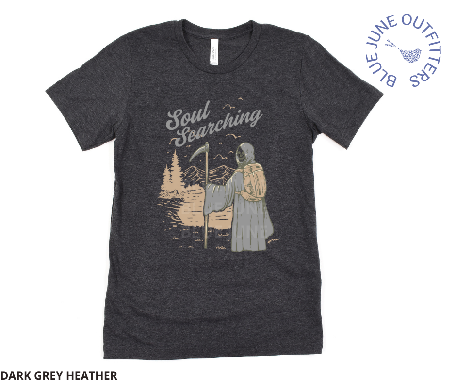 Super soft Bella + Canvas brand tee in dark heather grey. This shirt from Blue June Outfitters' exclusive Morbid Nature Collection features the grim reaper backpacking in nature. The phrase soul searching is printed above. Perfect for those who appreciate dark humor!