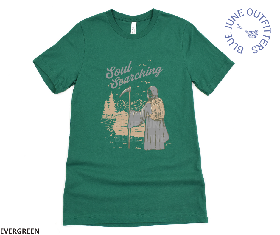 Super soft Bella + Canvas brand tee in evergreen. This shirt from Blue June Outfitters' exclusive Morbid Nature Collection features the grim reaper backpacking in nature. The phrase soul searching is printed above. Perfect for those who appreciate dark humor!