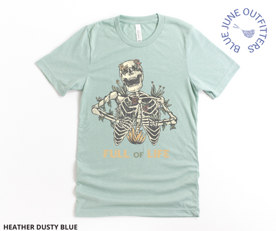 Super soft Bella + Canvas brand shirt in heather dusty blue. This tee is from Blue June Outfitters' exclusive Morbid Nature Collection. It features a skeleton covered in plants has the phrase full of life underneath.