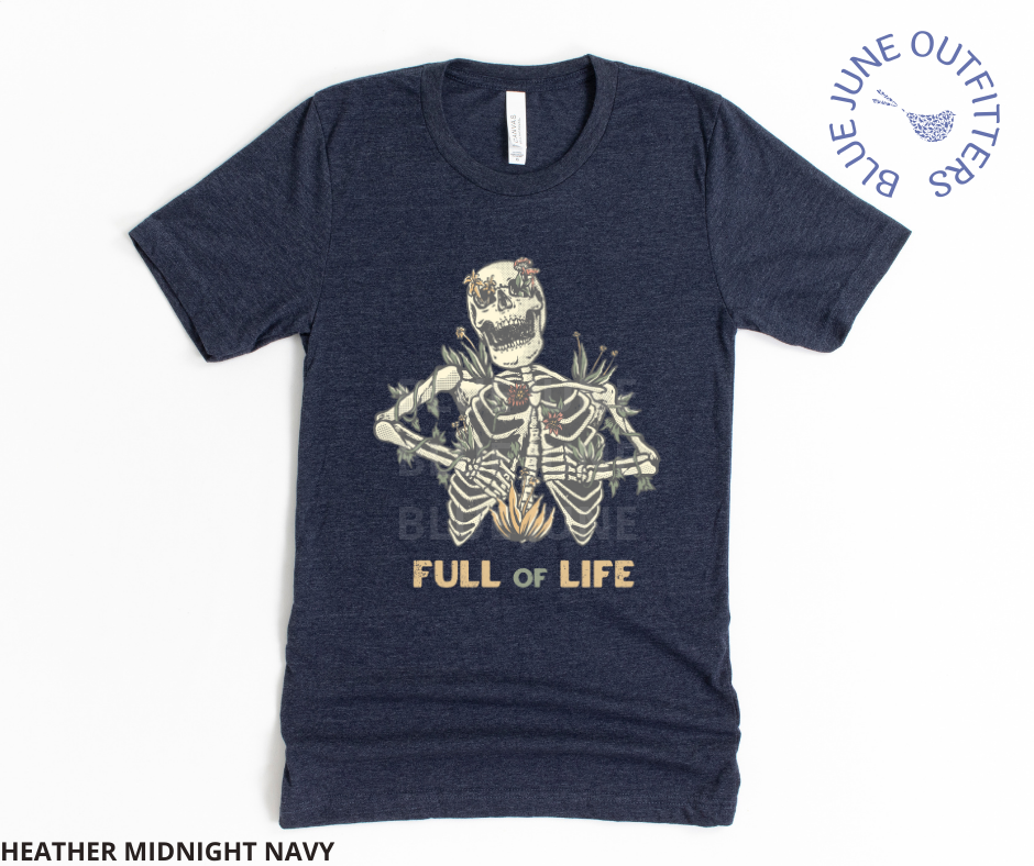 Super soft Bella + Canvas brand shirt in heather midnight navy. This tee is from Blue June Outfitters' exclusive Morbid Nature Collection. It features a skeleton covered in plants has the phrase full of life underneath.