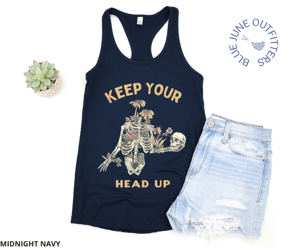 Super soft women's slim racerback tank top in midnight navy. This tank is from Blue June Outfitters exclusive Morbid Nature Collection and features a skeleton wrapped in plants and wildflowers holding his on skull up with his hand. The phrase keep your head up is printed. Perfect for those who appreciate dark humor!