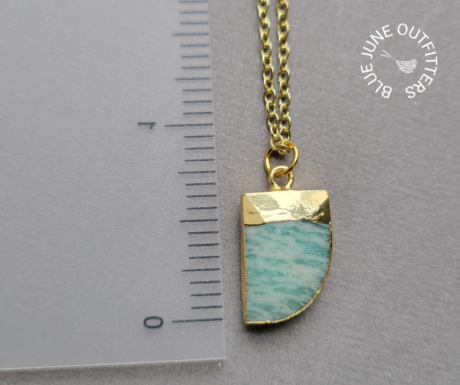 Close view of the pendant showing the green coloring and faceted detailing. The pendant measures approximately over half an inch in height. 