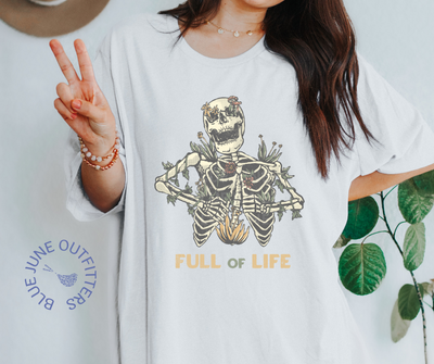 Super soft Bella + Canvas brand shirt in white. This tee is from Blue June Outfitters' exclusive Morbid Nature Collection. It features a skeleton covered in plants has the phrase full of life underneath.