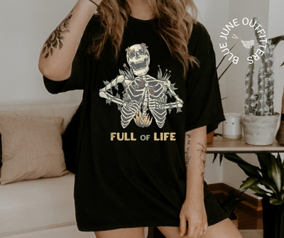 Super soft Bella + Canvas brand shirt in black. This tee is from Blue June Outfitters' exclusive Morbid Nature Collection. It features a skeleton covered in plants has the phrase full of life underneath.