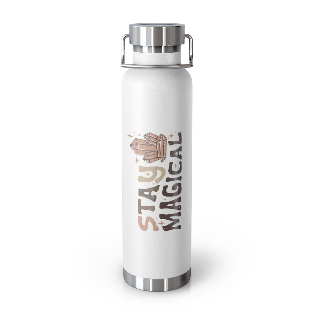 White 22 ounce vacuum insulated bottle with stainless steel lid and handle.  The artwork is vertical. The text reads Stay Magical. There are metaphysical crystals and stars.  The colors are earthy, fun and rich. 
