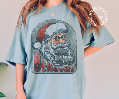 Don't Stop Believin' | Comfort Colors® Groovy Santa Christmas Tee