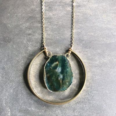 Beautiful emerald green raw chrysoprase slice pendant surrounded by gold electroplating. It is encompassed by a brass semi-circle accent. The chain is 30" with a 2" extender and is hypo allergenic gold plated.